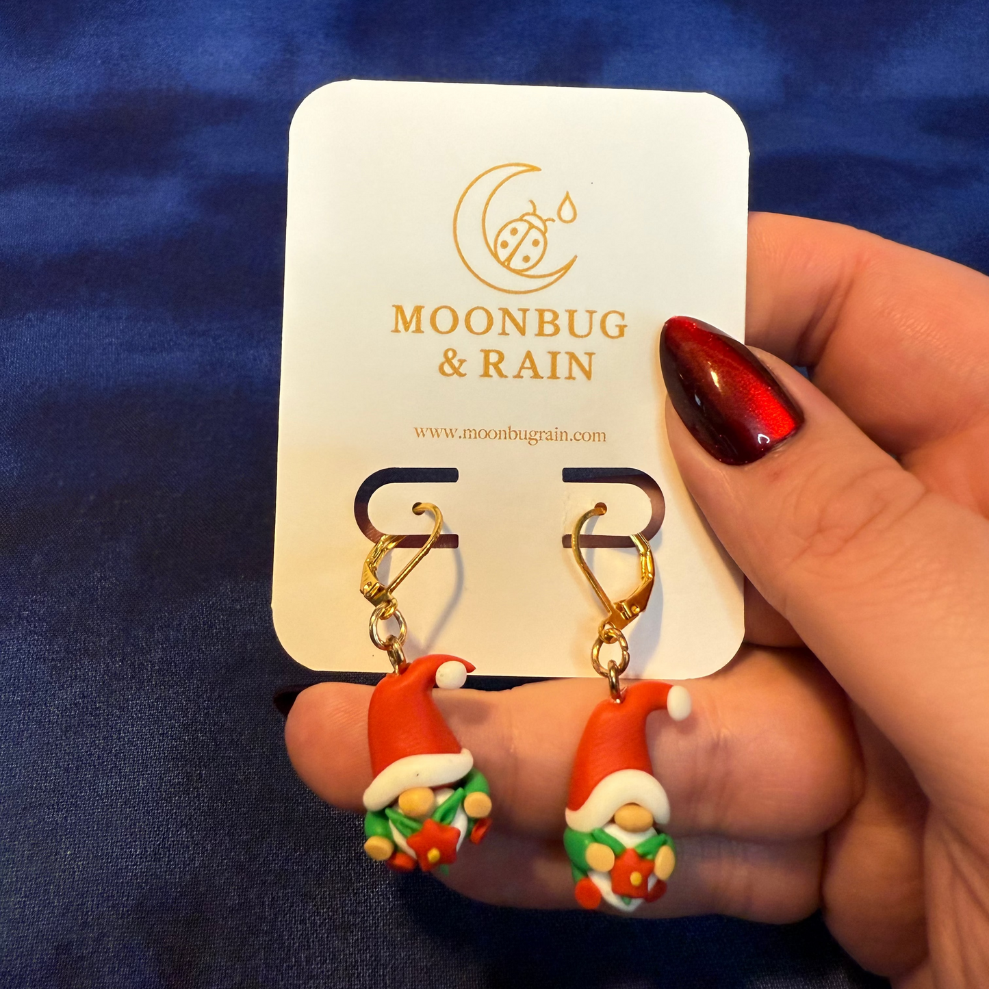 Gnome-themed earrings on a 'Moonbug & Rain' card against a blue background